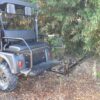A black golf cart parked in the woods